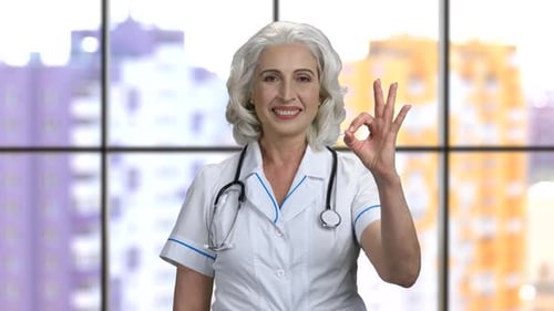 Senior Doctor Smiling and Giving OK Gesture
