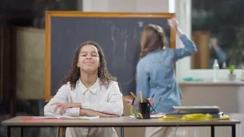Girl at Desk in Classroom Smiling