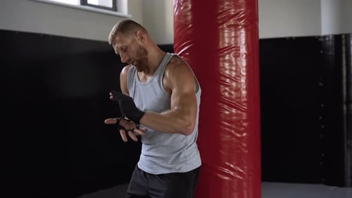 Boxer Wrapping Hands in Gym before Training