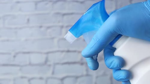 Hand in Glove Spraying Disinfectant Cleaner