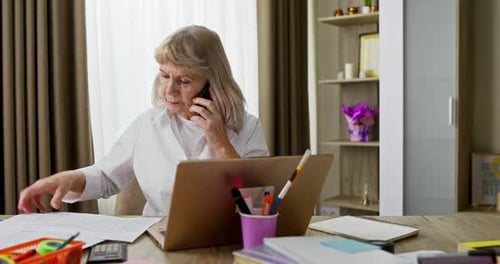 Mature Woman Working at Home on Cell Phone