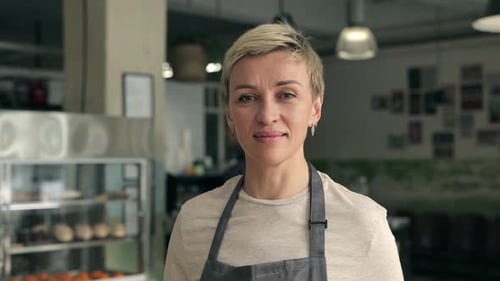 Portrait of Mature Lady in Apron Standing at Cafeteria