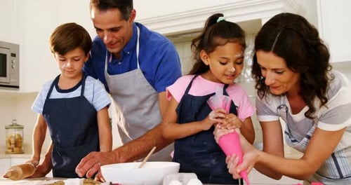 Happy Family Decorating Cookies Together in Kitchen