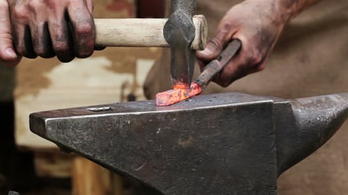 Blacksmith Shaping Red Hot Metal on Anvil