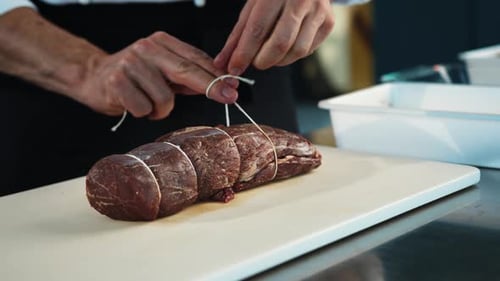 Close-up: The chef cuts the meat of the filet mignon with a knife. The process of preparing food