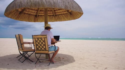 Man Working on Laptop at Tropical Beach