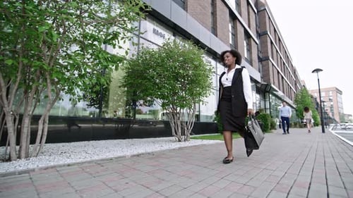 Confident Woman Walks Outside Modern Business