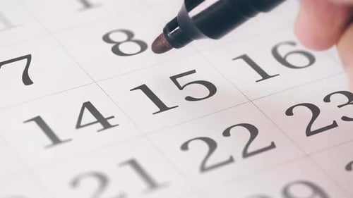 Marking Tax Day on Calendar with Red Marker