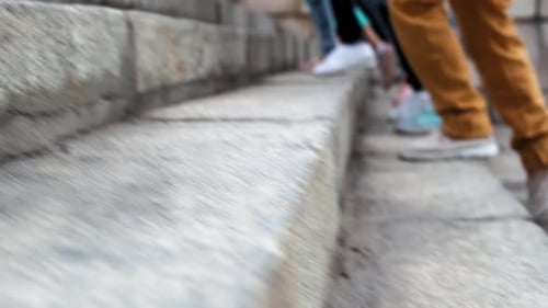 Blurred Legs of Schoolchildren Run Up Stairs Together on Sunny Day