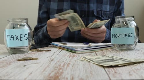 Man Budgeting Money for Mortgage and Taxes at Home