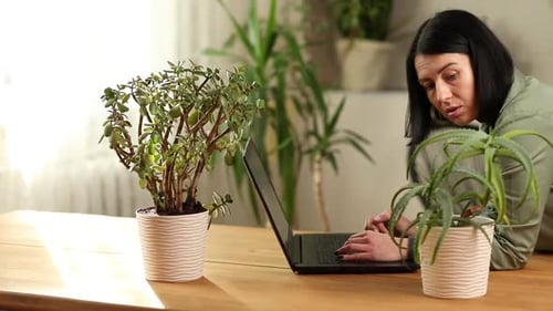 Woman Uses Laptop Computer at Home at Desk