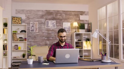 Man Working on Laptop at Home Office Desk
