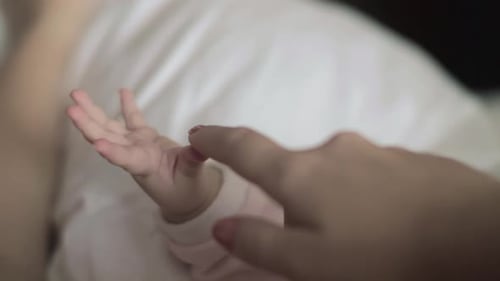 Maternal Love. Mother Touching Baby Hand