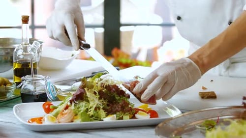Chef Preparing Salad with Meat in Kitchen