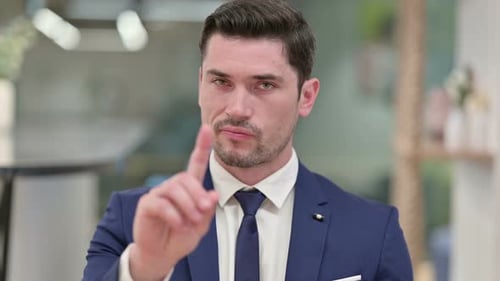 Seriöser junger Geschäftsmann sagt Nein mit dem Finger