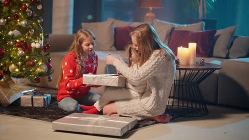 Two Girls with Mother Near Christmas Tree and Opening Gifts
