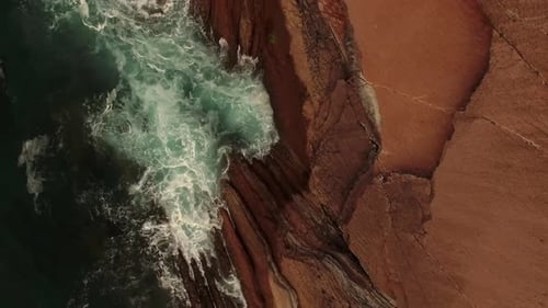 Stormy sea waves splashing on rocky cliff
