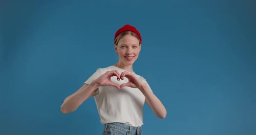 Smiling Woman Making Heart Shape with Hands