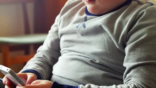 Child Playing Game on Cell Phone Indoors