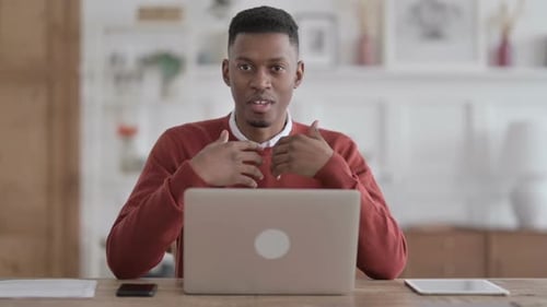 African Man with Laptop Talking on Video Call in Office