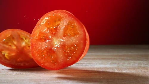 Tomato slices rolling in ultra slow motion