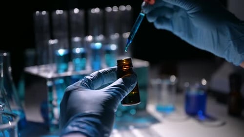 Gloved Hands Adding Liquid in Laboratory Close Up