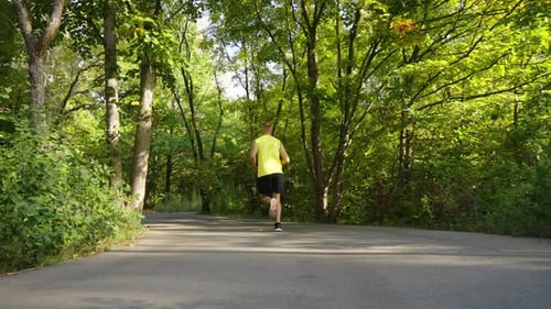 Slow Motion Jogger Running in Park in Summer