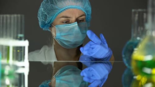 Un scientifique met des gants au début de la journée de travail, uniforme de protection