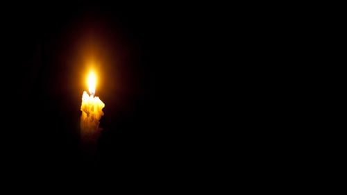 Wax Candle Burning Brightly in Dark Setting