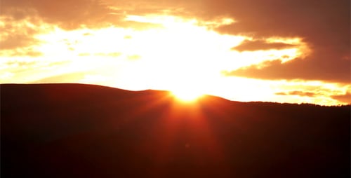 Dramatic Sunset Over Distant Mountain Range