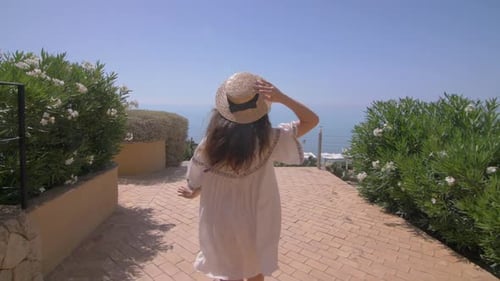 Woman Walks Down Path to Beach View on Summer Day