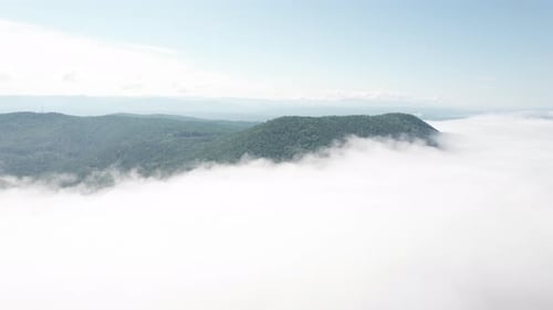 Flying Through the Clouds Above Mountain Tops