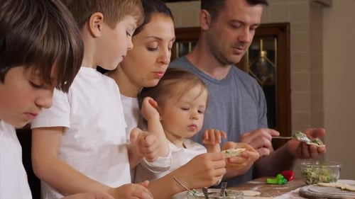 Family Enjoys Making Dumplings Together in Kitchen