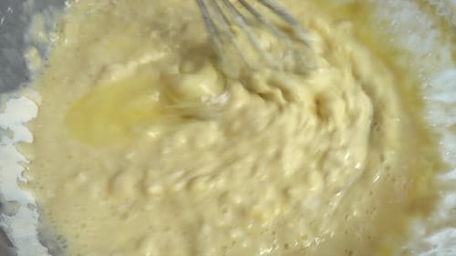 Der Prozess der Herstellung von Teig aus Mehl, Milch und Eiern.