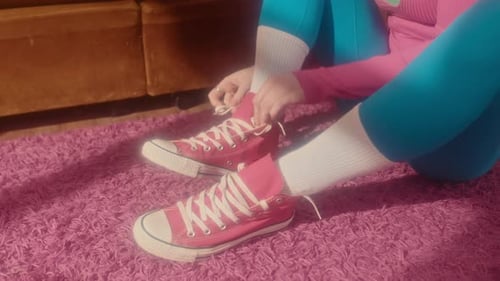 Person Tying Red Sneakers on Pink Shag Carpet