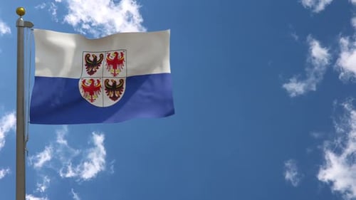 Waving Flag with Coat of Arms Against Blue Sky