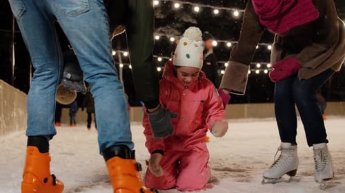 Glückliche Familie auf der Eisbahn im Winter