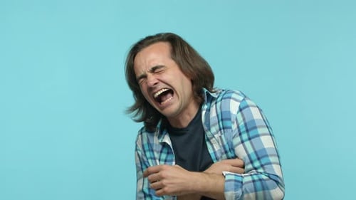 Man Yelling in Pain Against Blue Background