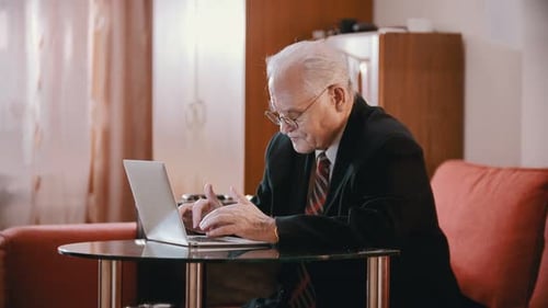 Senior Man Using Laptop at Home