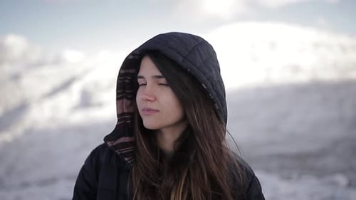 Tourist in outerwear against high ridges in wintertime