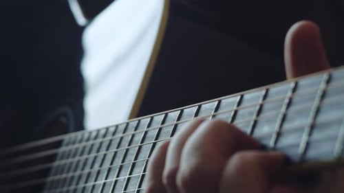 Close Up of Person Playing Acoustic Guitar