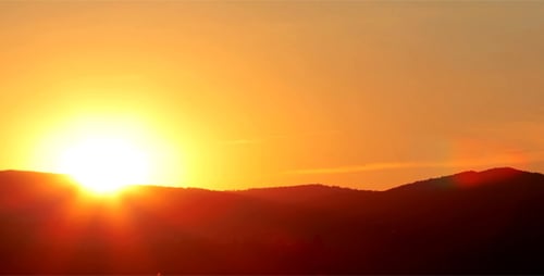 Fiery Sunset Over Mountainous Horizon Time-Lapse