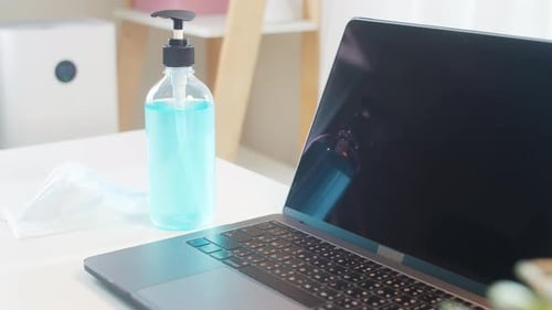 Laptop, Sanitizer, and Mask on Desk