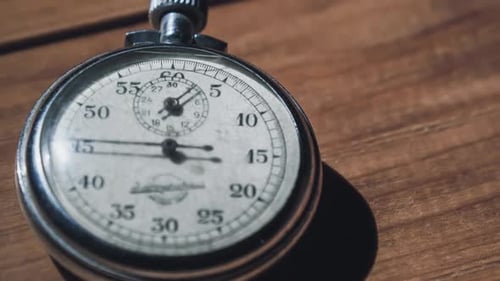 Vintage Stopwatch Lies on Wooden Table and Counts the Seconds Timelapse