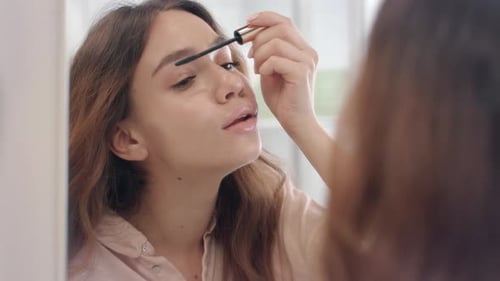 Beautiful Woman Using Mascara for Eyelashes Front Bathroom Mirror