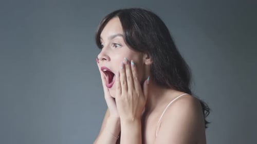 Surprised Woman Holding Hands to Face