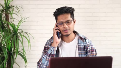 Man Talks on the Phone While Working