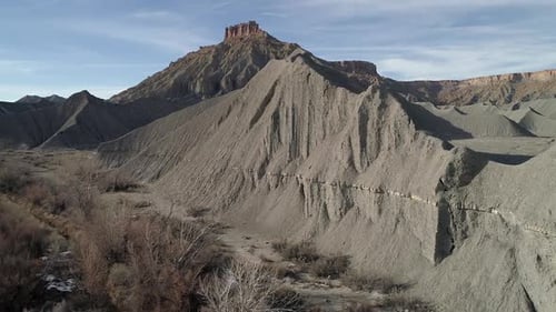 Flying over desert dunes viewing mesa towering above