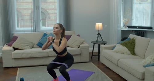 Woman Exercising At Home with Resistance Band