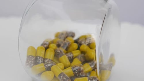 Yellow Capsules in Glass Jar Tumble